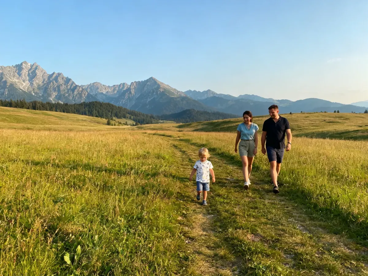 Dziecko z rodzicami na Rusinowej Polanie z widokiem na Tatry