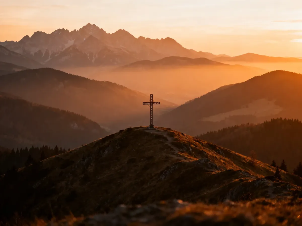 Krzyż na Litwince na tle szerokiej panoramy gór o zachodzie słońca